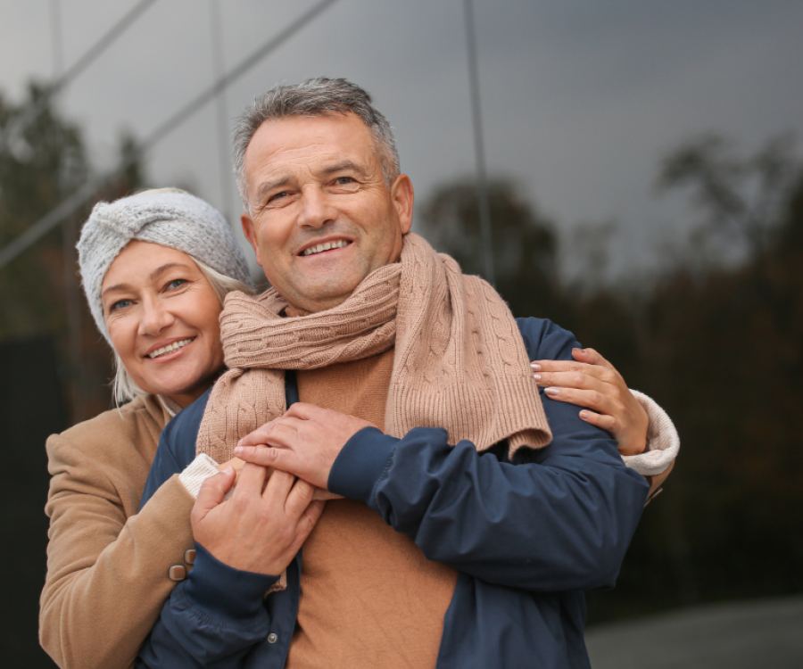 A couple smiling outdoors in autumn